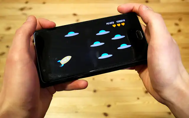 Hand holding a smartphone while using a mobile app